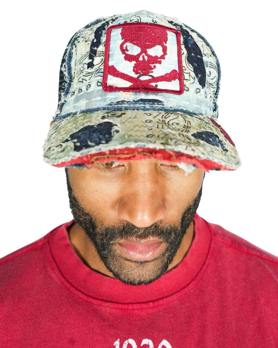 Man wearing a colorful cap with a red skull design and a red shirt.