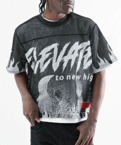 Man wearing a black graphic mesh shirt with bold white text and skull design.