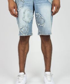 Man wearing light blue distressed denim shorts with white sneakers.