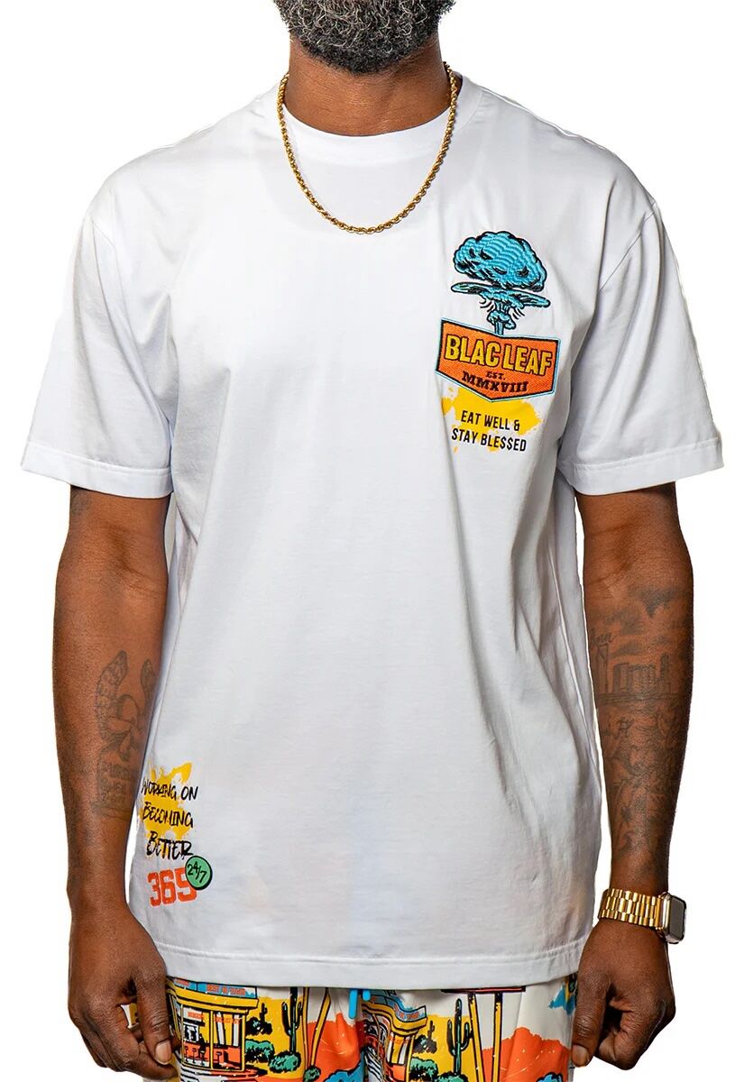 White t-shirt with colorful graphic prints and rolled sleeves.